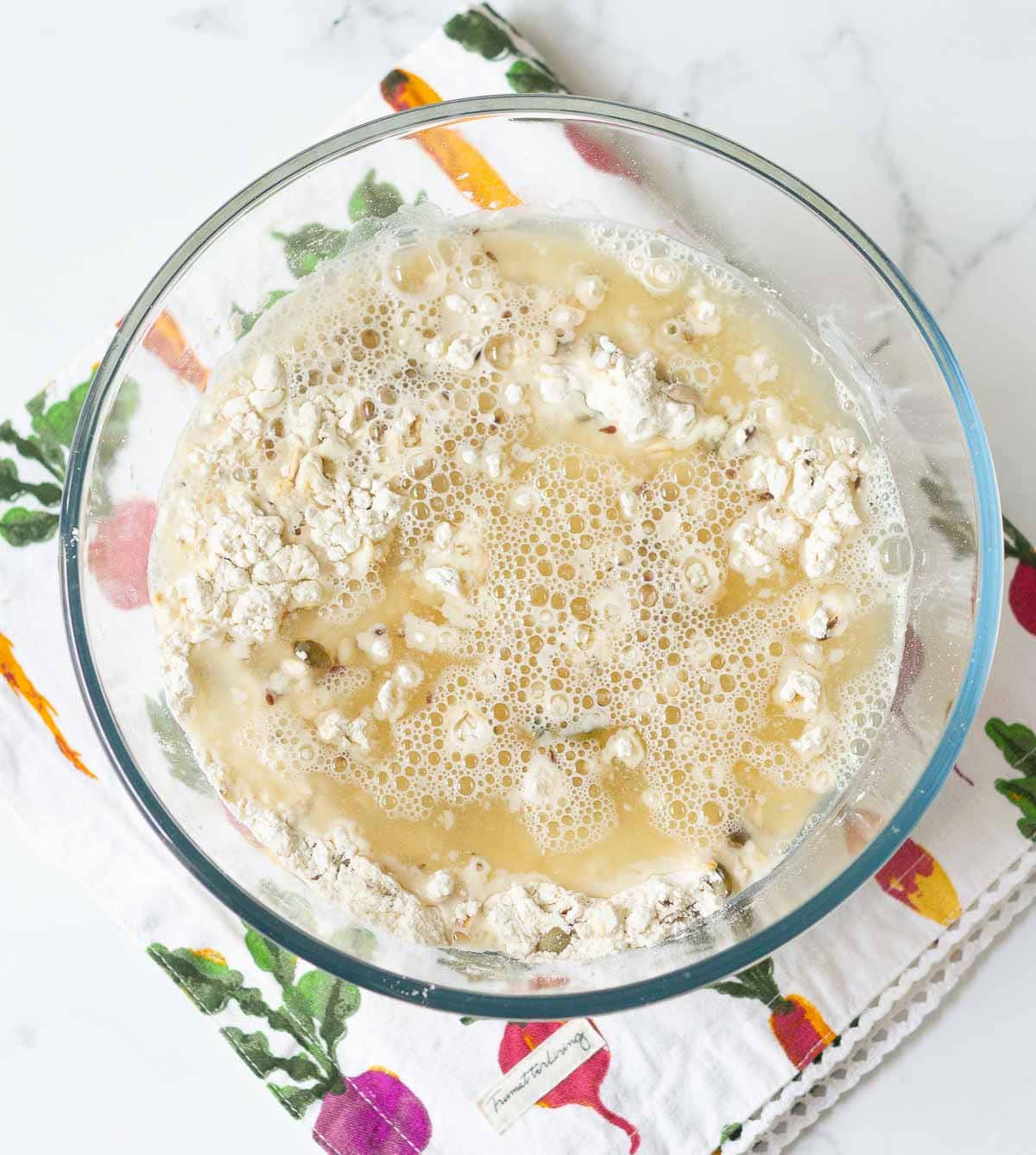 water and dry ingredients for bread in a mixing bowl.