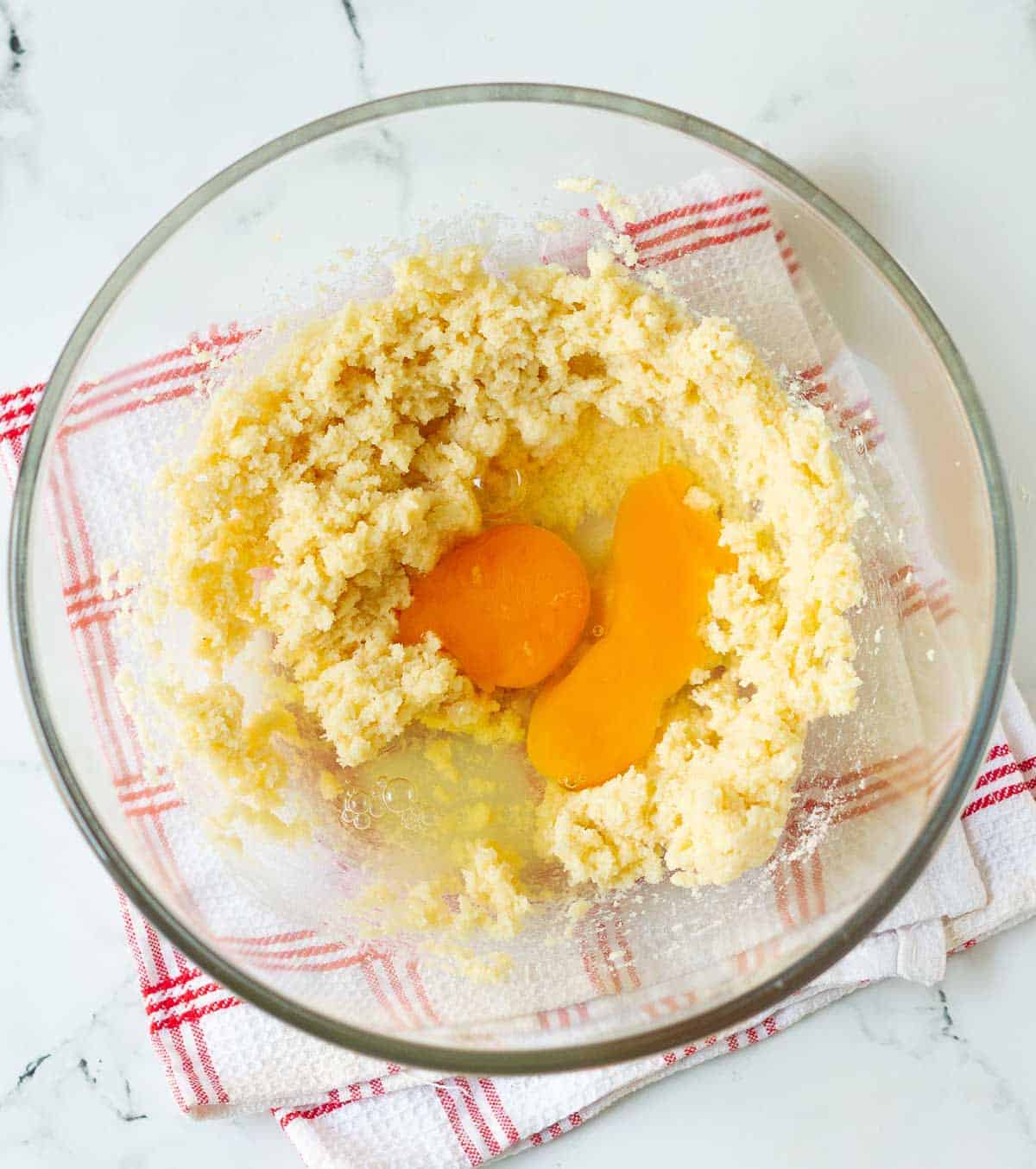 Butter-sugar mixture with eggs in a mixing bowl.