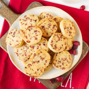 A plate full of cranberry cookies on a red napkin.