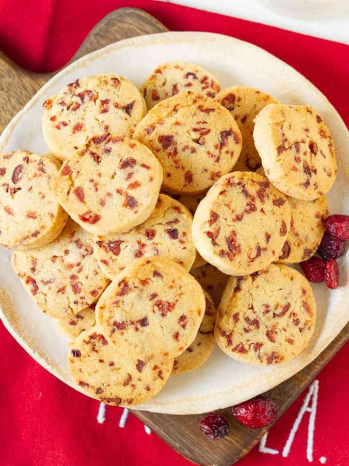 A plate full of cranberry cookies on a red napkin.