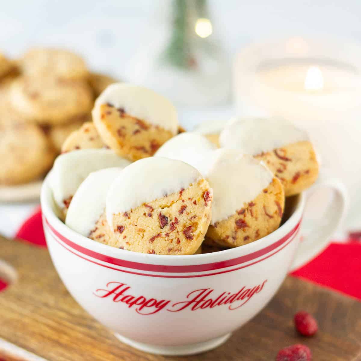 A cup full of cookies half dipped in white chocolate.