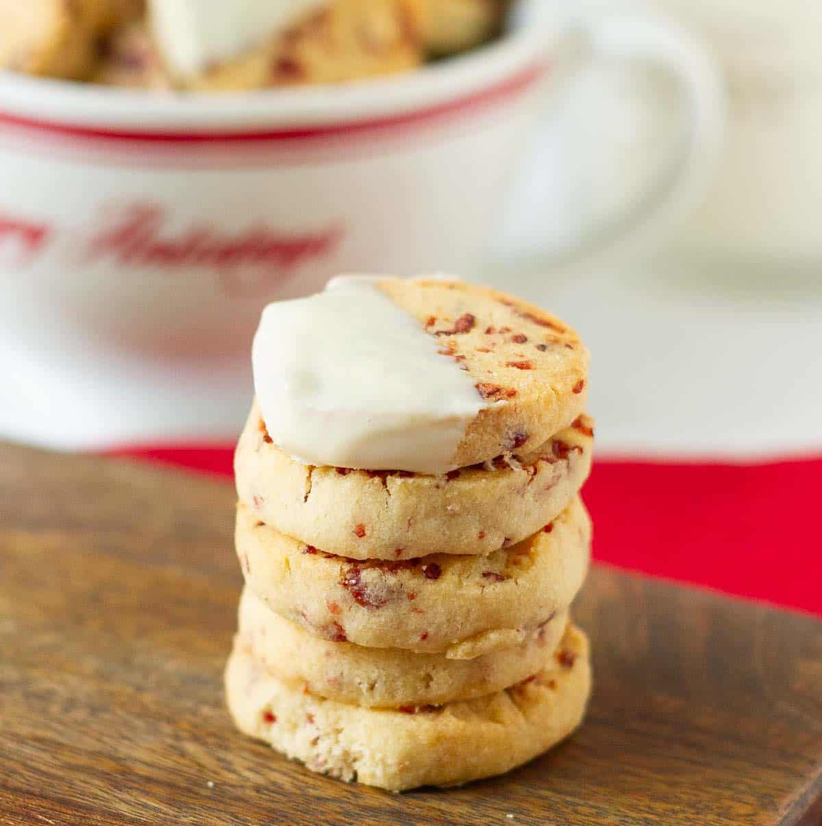 A stack of cookies with one half dipped in white chocolate on top.