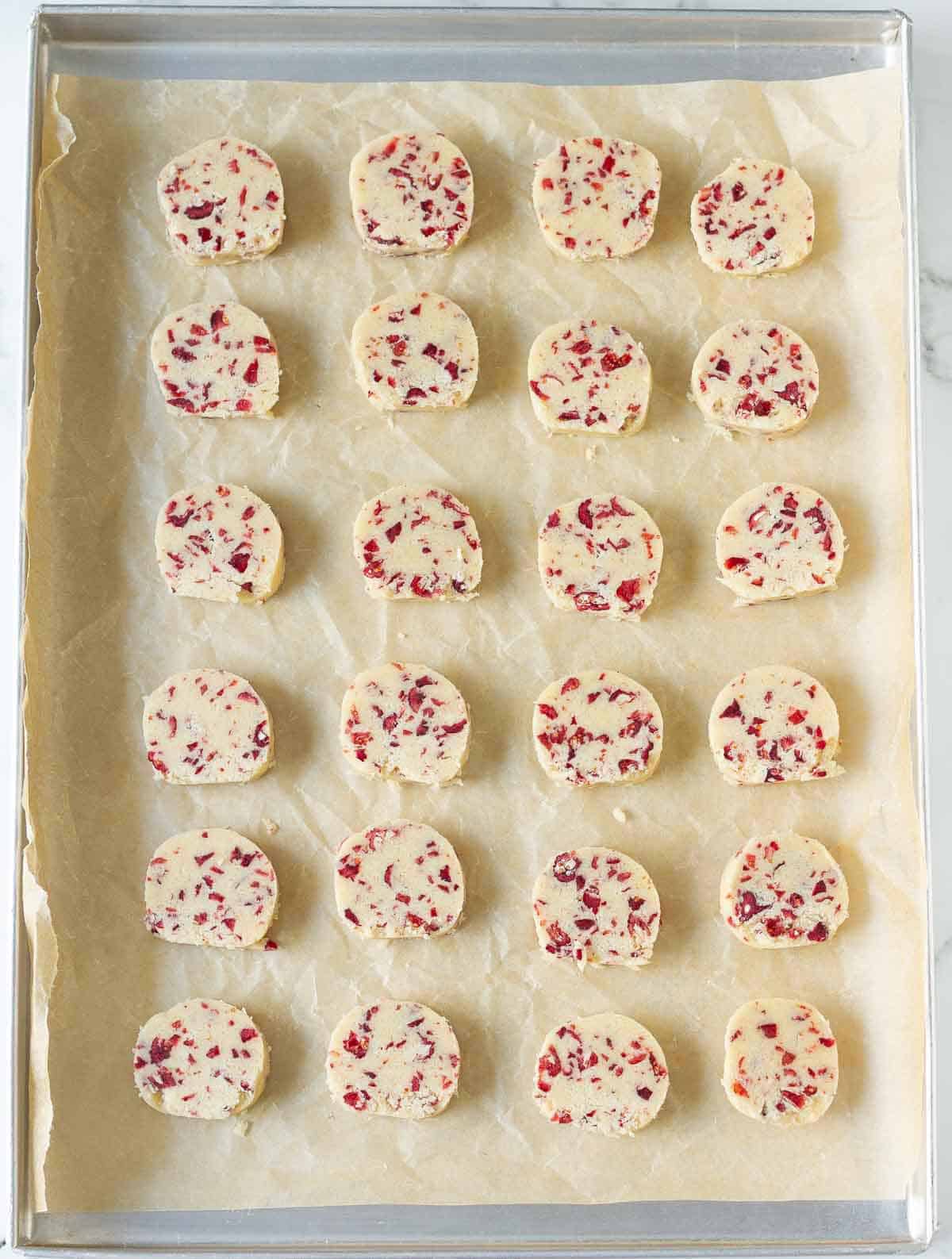sliced cookie dough on parchment-lined tray.