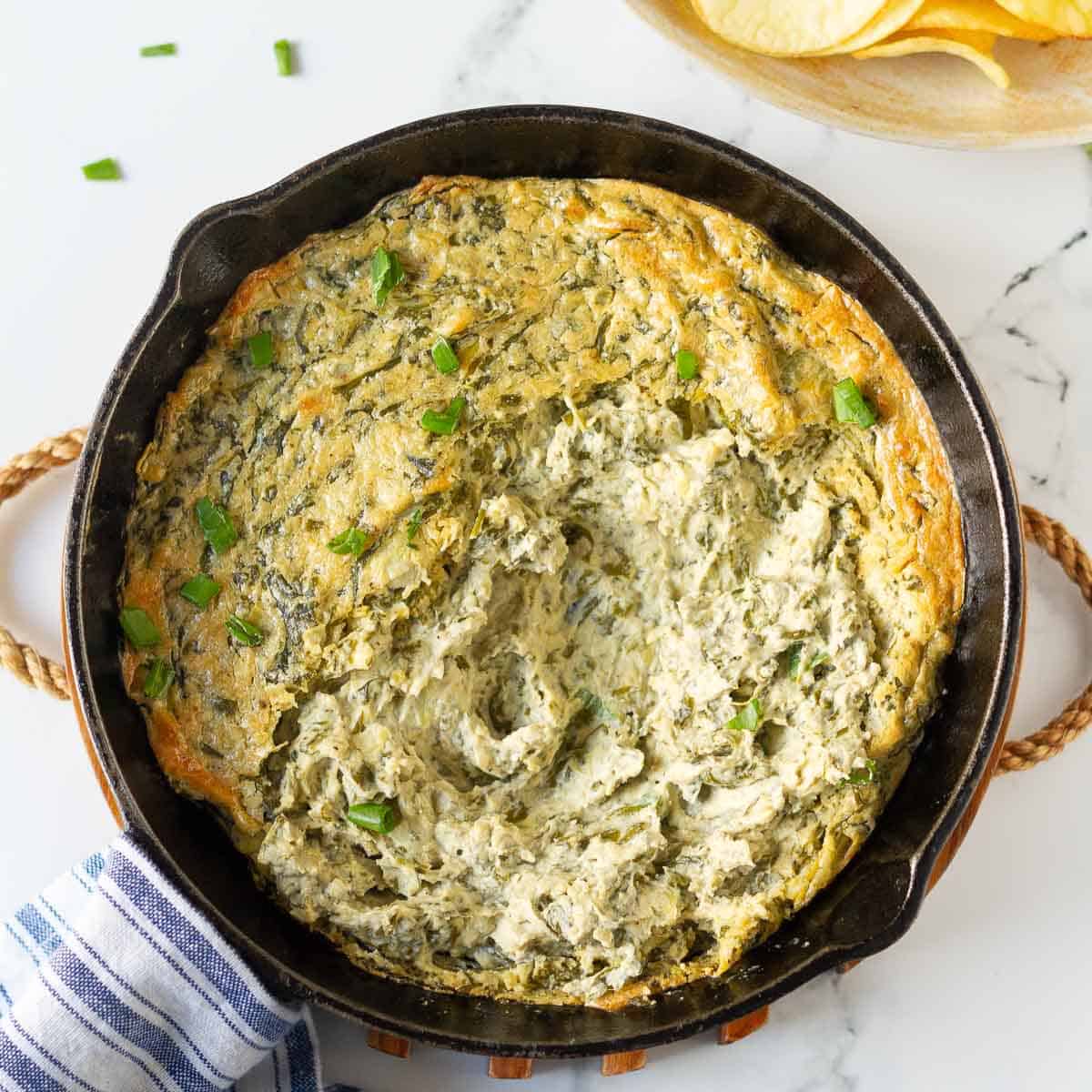 Spinach artichoke dip in a cast-iron pan.