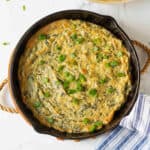 Baked vegan spinach artichoke dip in a cast-iron pan.