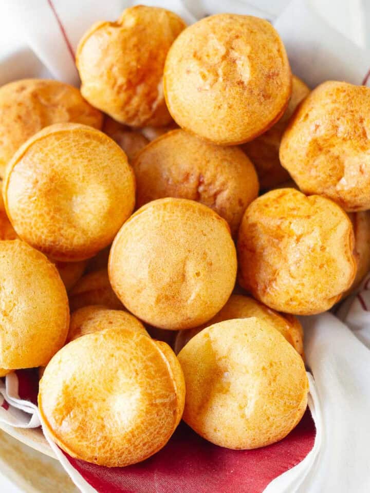 Brazilian cheese bread rolls in a bowl lined with red and white napkin.