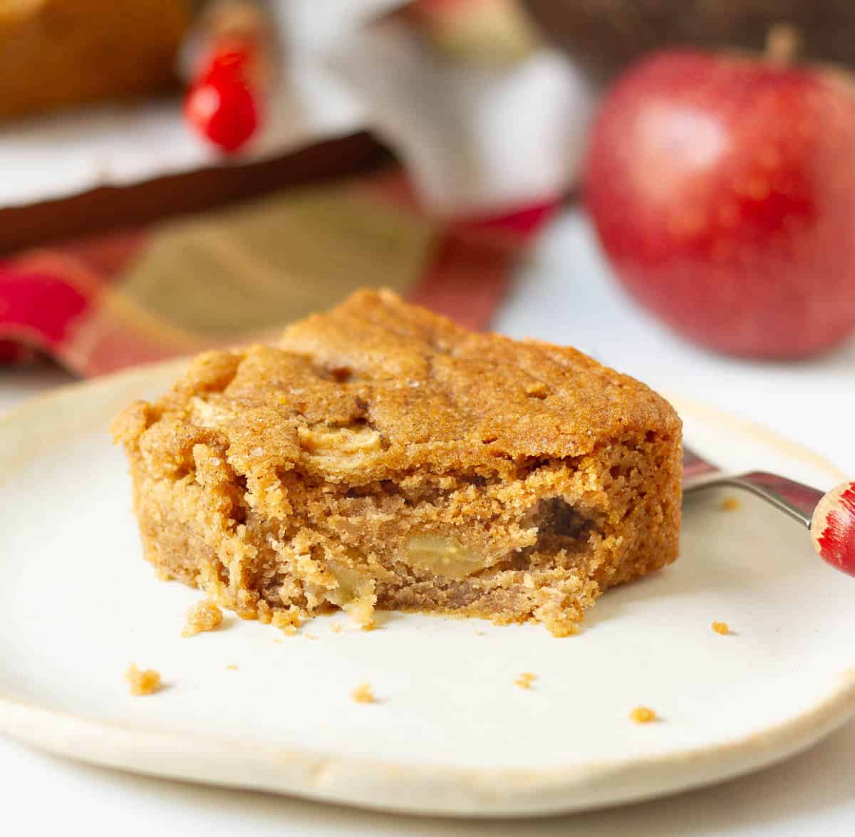 A bite taken from an apple bar kept on a plate.