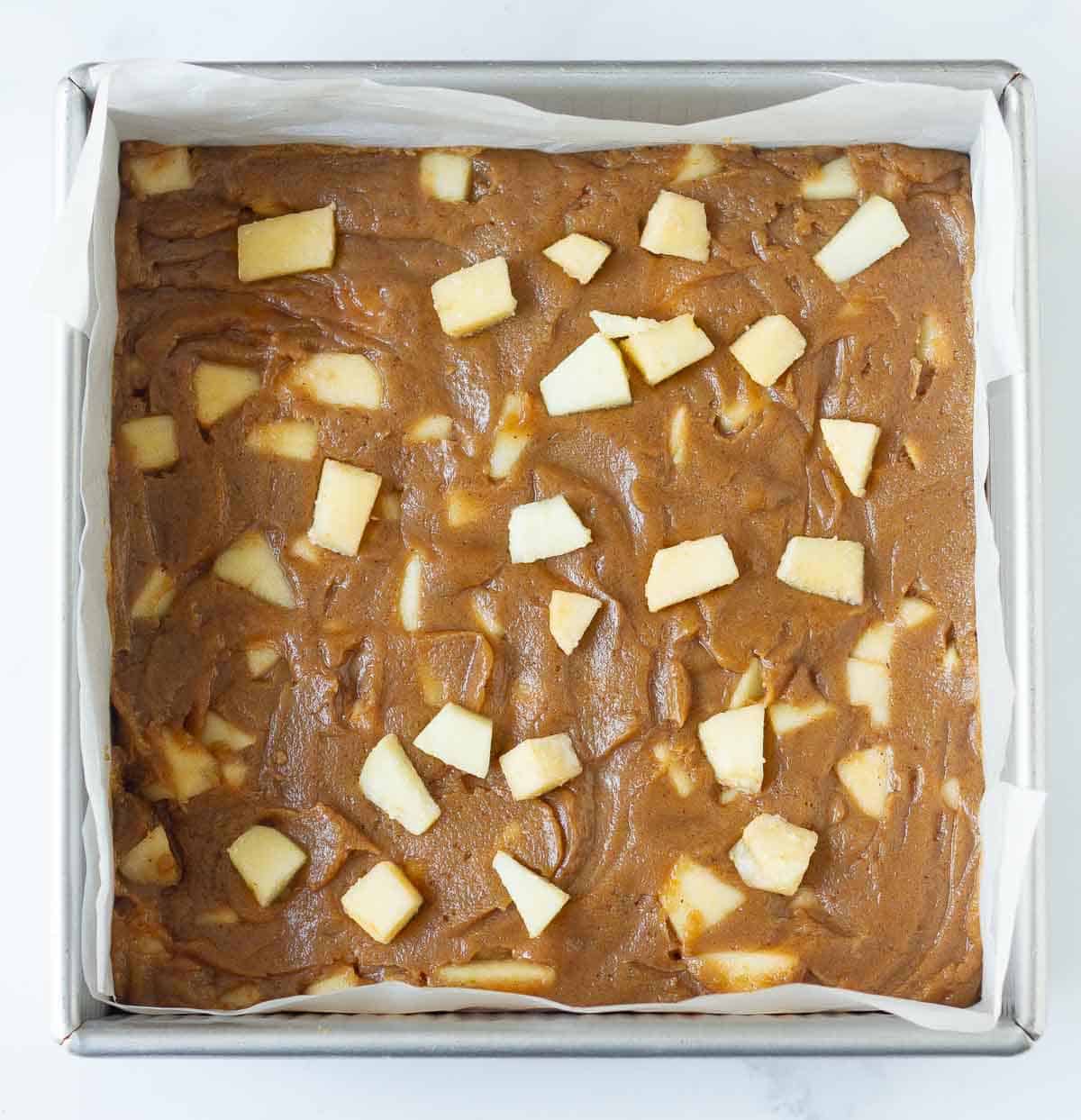 Blondies batter in a parchment-lined pan.