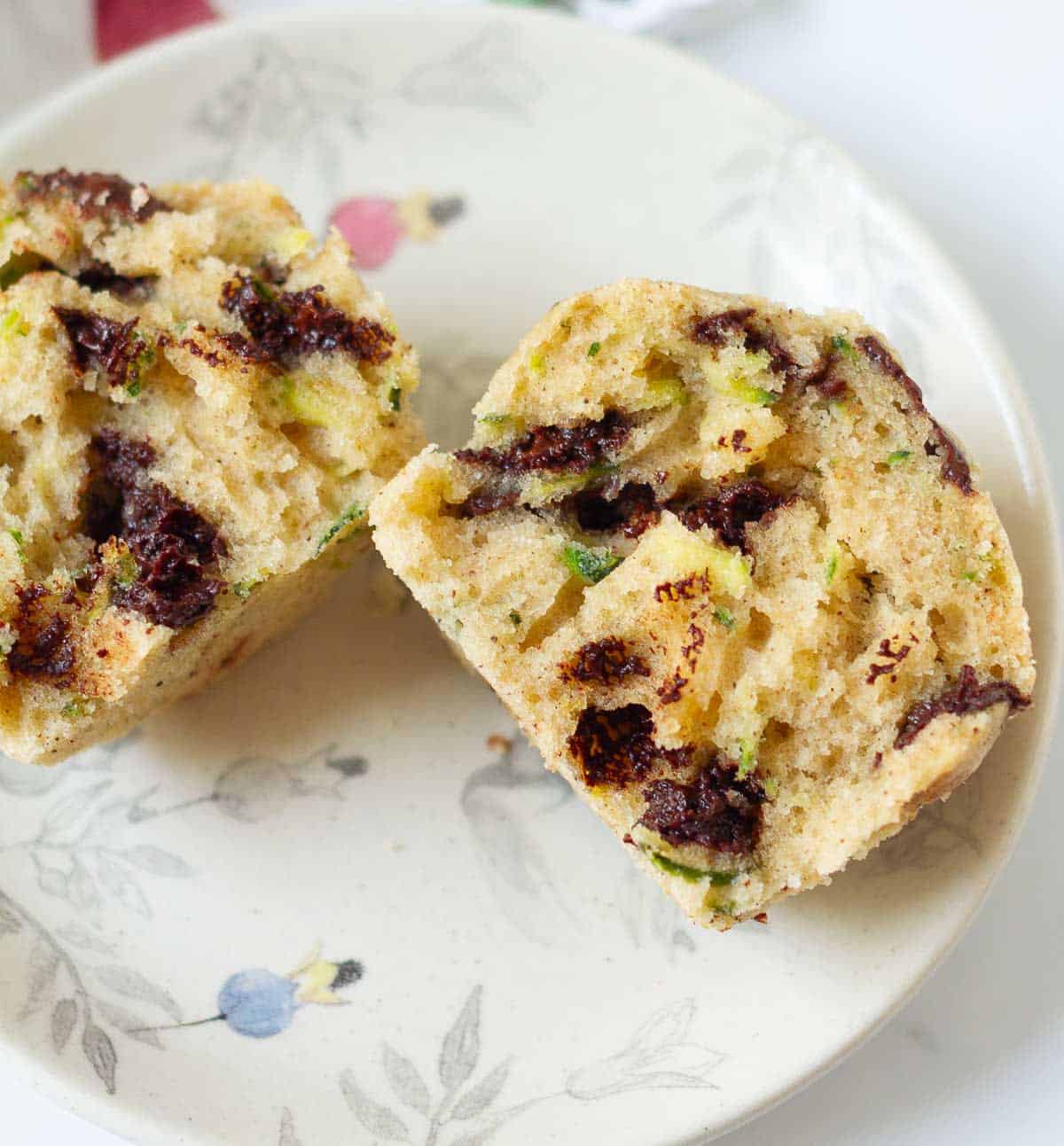A muffin cut in half on a small plate.