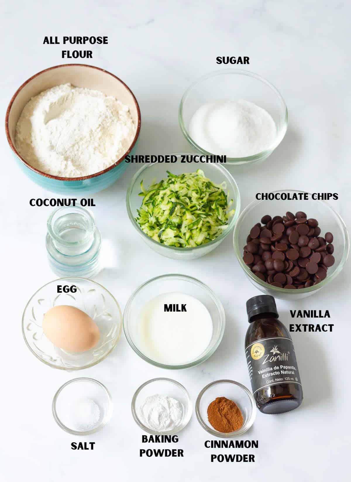 Labeled ingredients for making chocolate chip zucchini muffins.