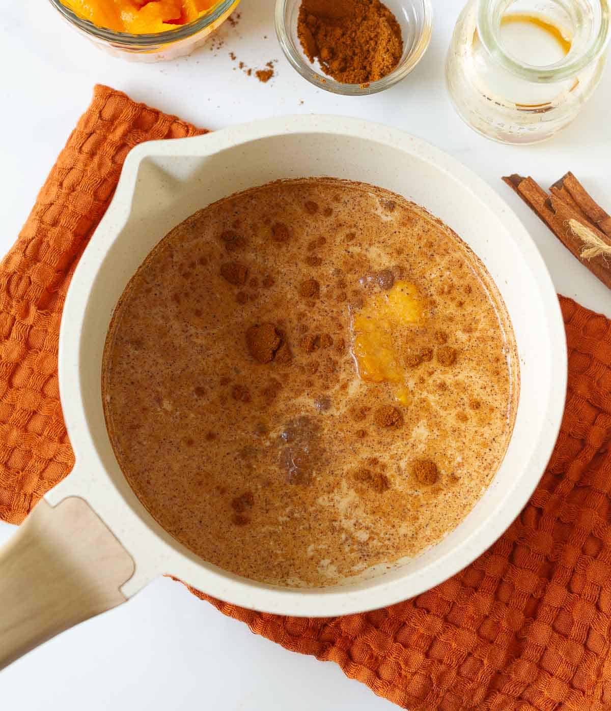 Milk, pumpkin puree, maple syrup, pumpkin pie spice in a saucepan.