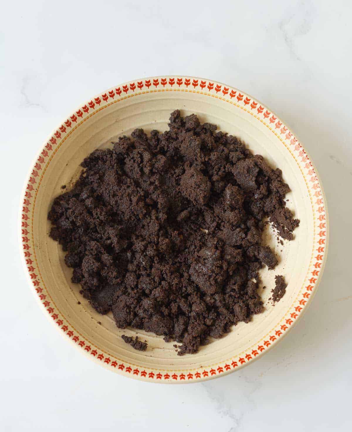 A mixture of melted butter and crushed Oreos in a bowl.