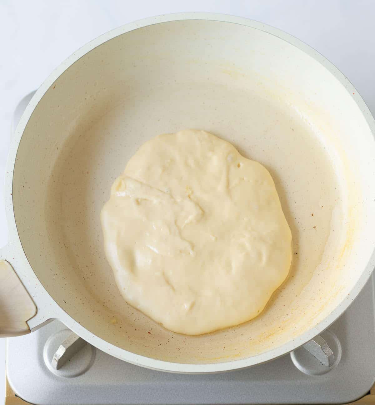 Pancake cooking in a skillet.