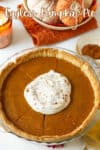 Eggless pumpkin pie in a pie dish with whipped cream on top.