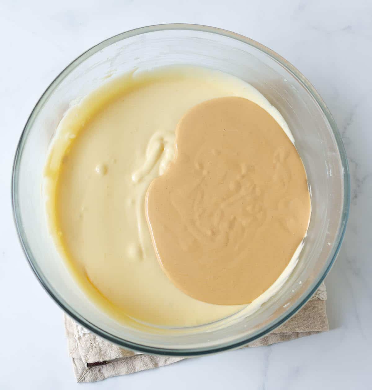 Cheesecake batter and tea-infused cream in a mixing bowl.