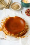 Chai cheesecake on parchment paper with spices in small bowls.
